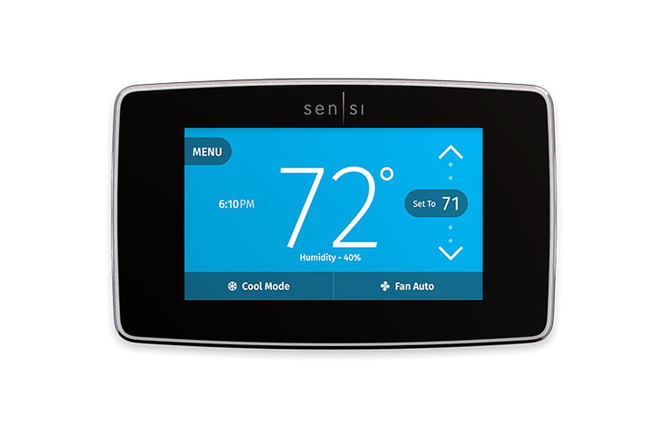 Hand turning a white thermostat dial to set the temperature to 68 degrees Fahrenheit.