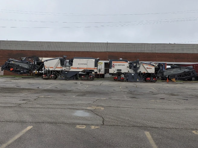 a bunch of trucks are parked in a parking lot in front of a building
