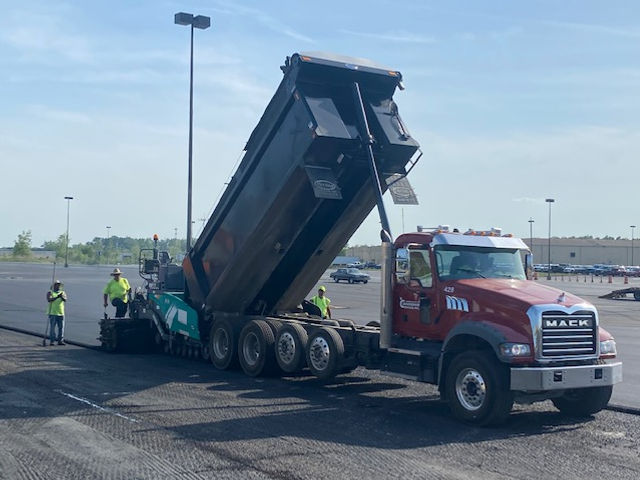 a mack dump truck is being loaded with asphalt