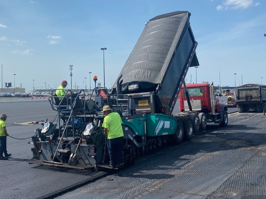 a group of construction workers are working on a road 