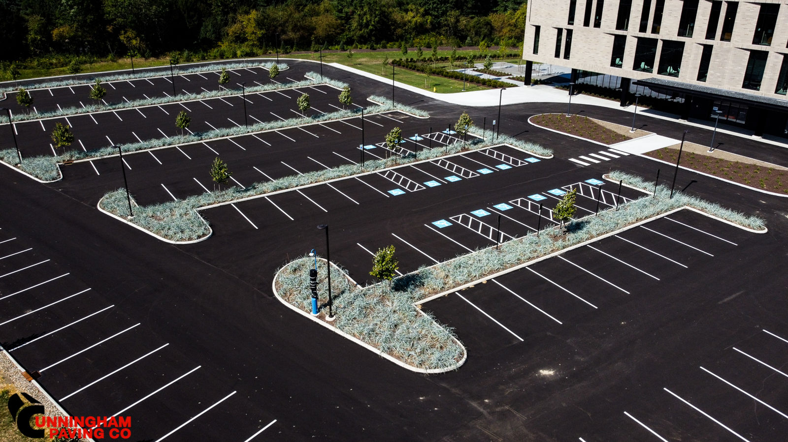 an aerial view of a parking lot with a building in the background