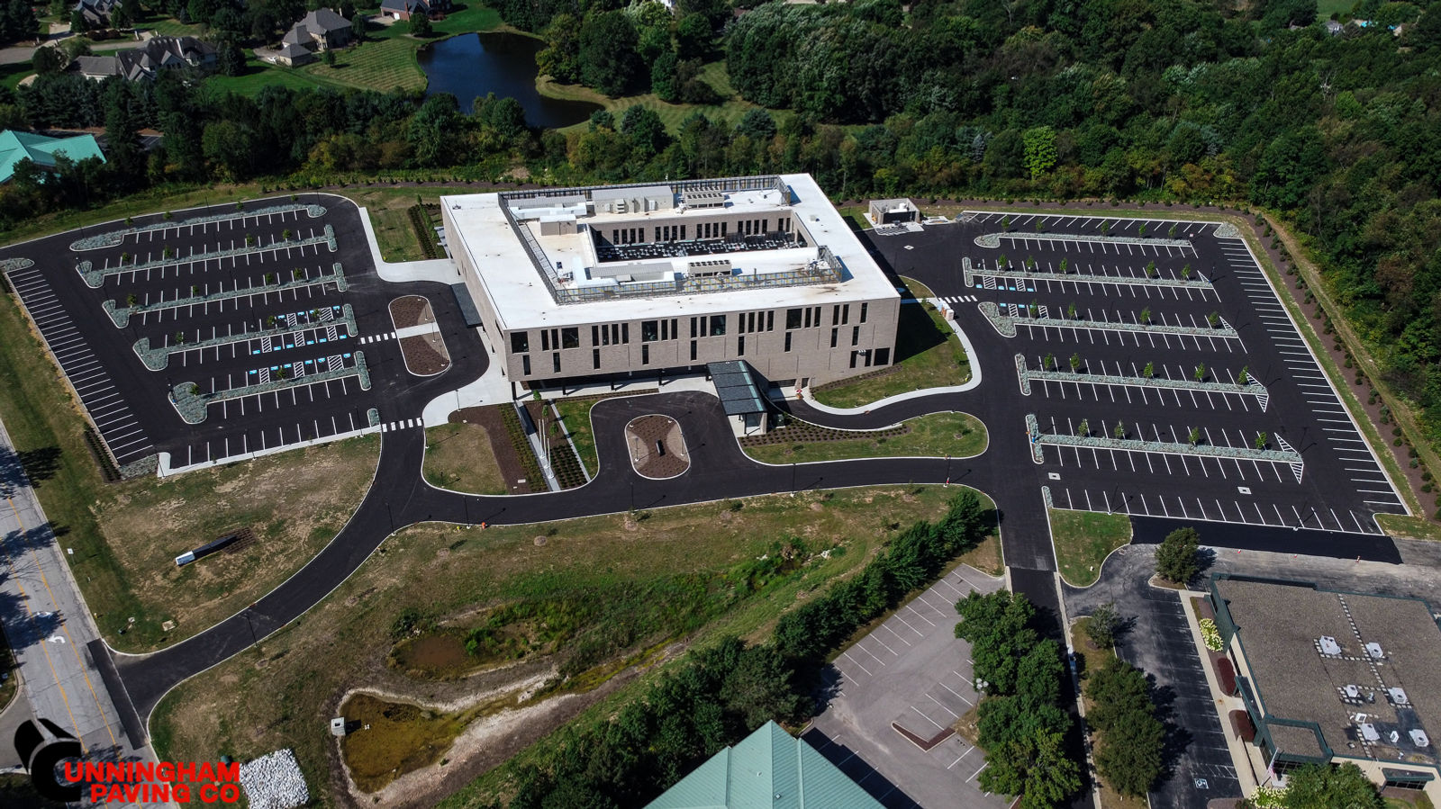 an aerial view of a large building surrounded by parking lots