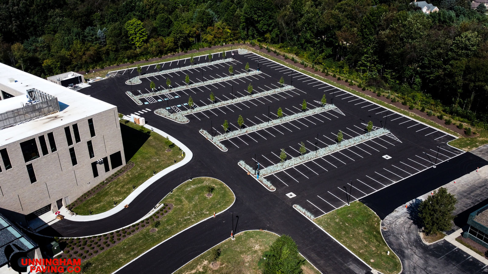 an aerial view of a parking lot with a building in the background
