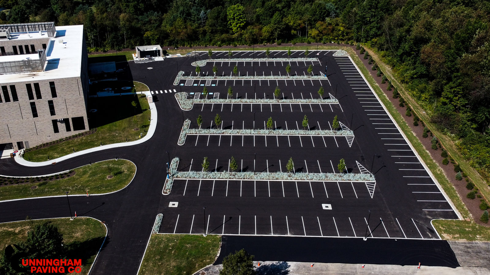 an aerial view of a parking lot with a building in the background