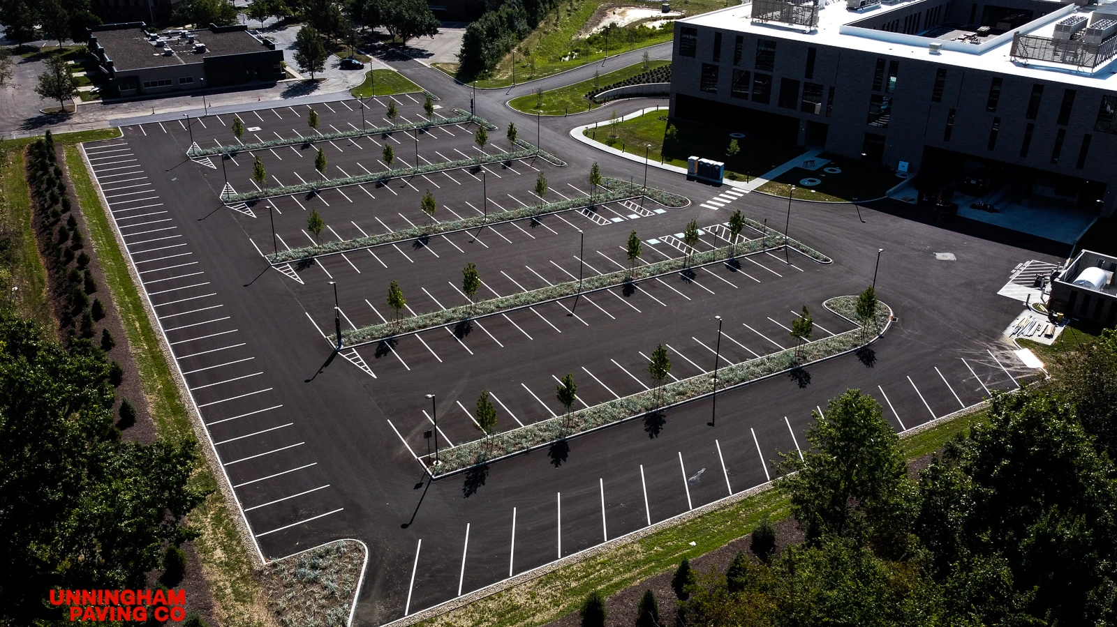 an aerial view of a parking lot with a large building in the background