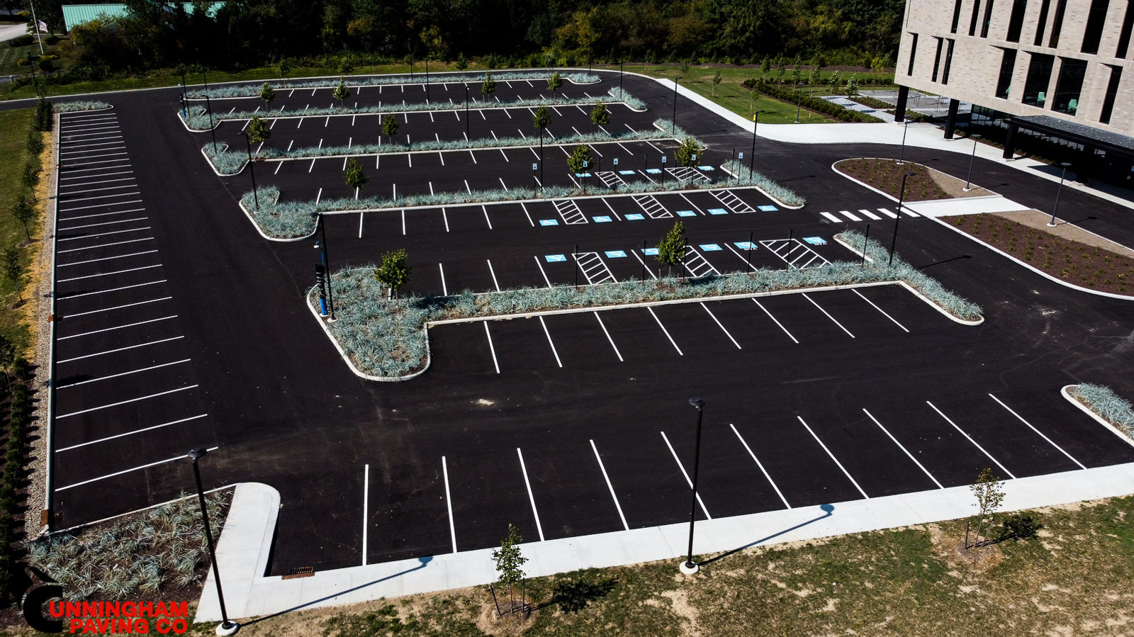 an aerial view of a parking lot with a building in the background