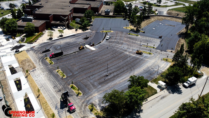 an aerial view of a parking lot with a building in the background