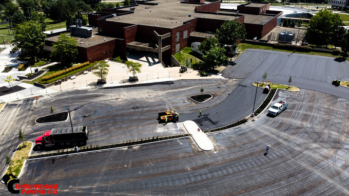 an aerial view of a parking lot with a large building in the background