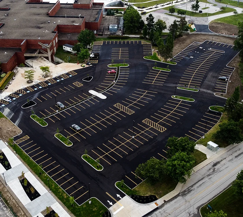 an aerial view of a parking lot with a building in the background