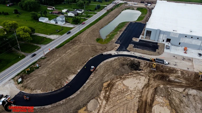 an aerial view of a road being built next to a building