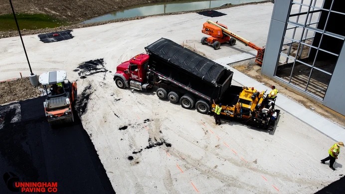 an aerial view of a truck being loaded with asphalt