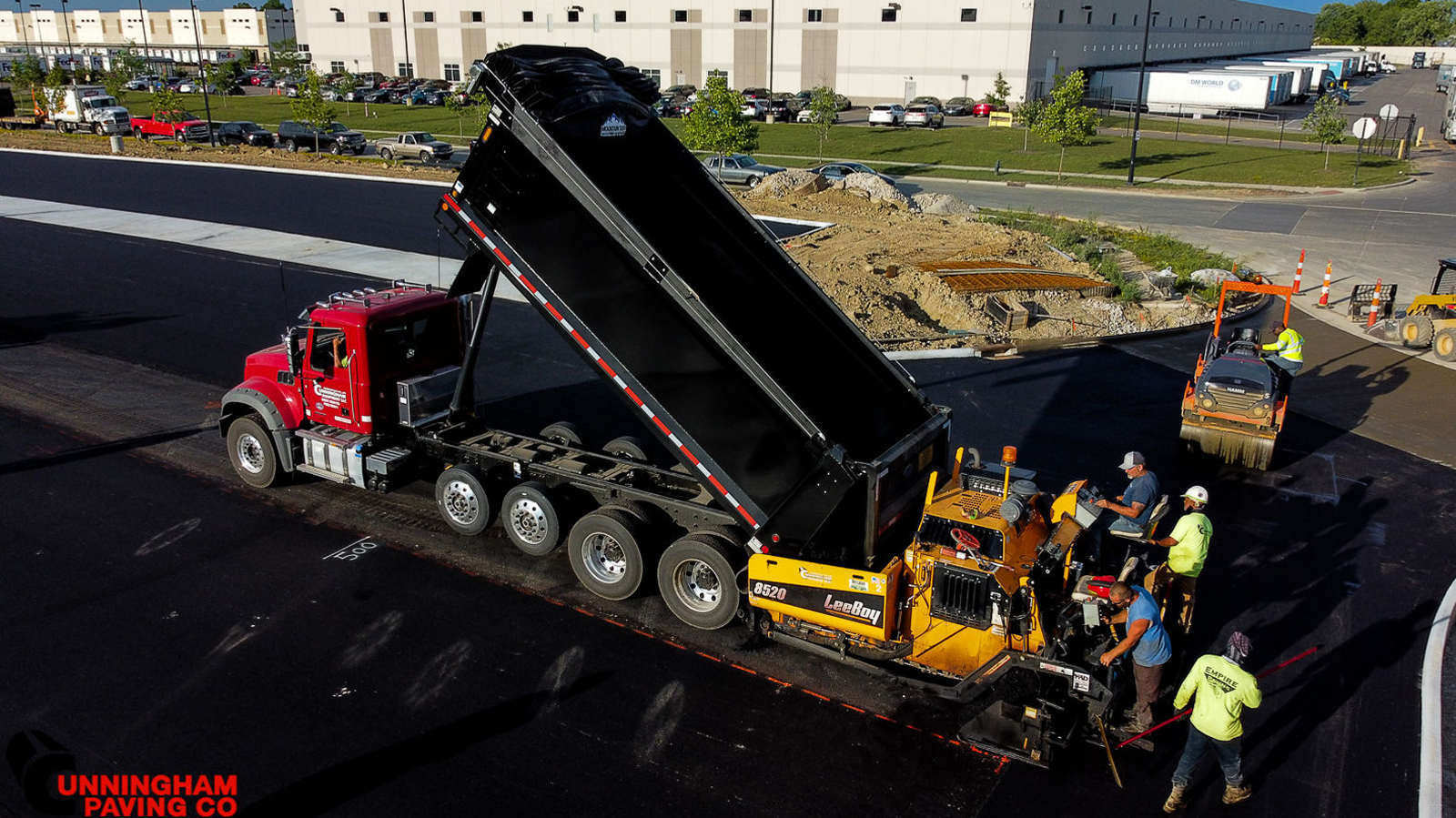 an aerial view of a dump truck being loaded with asphalt