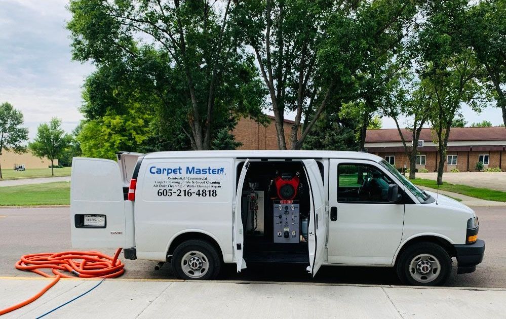 A white van with the doors open is parked on the side of the road.