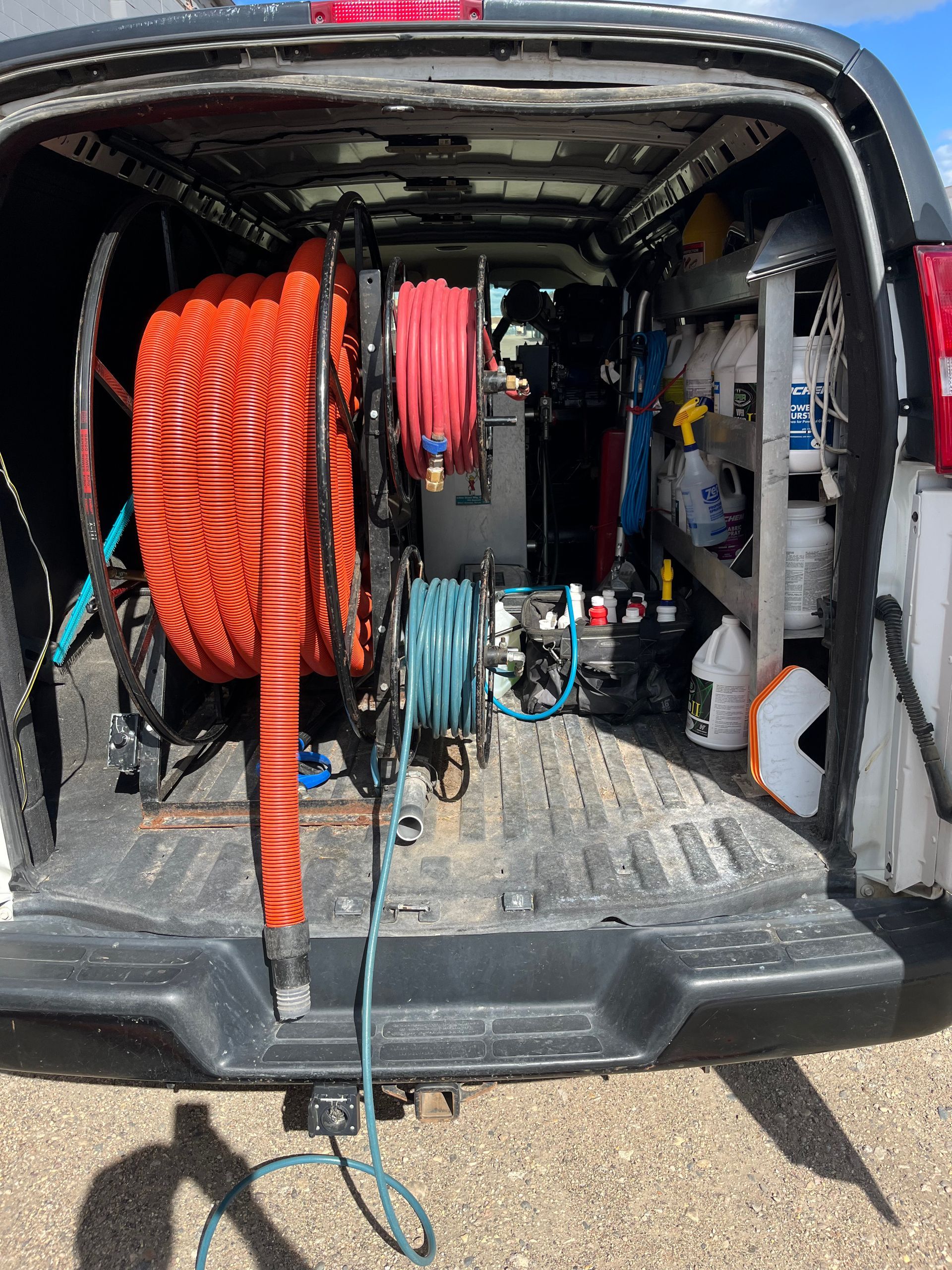 The back of a van with a hose on the back of it.