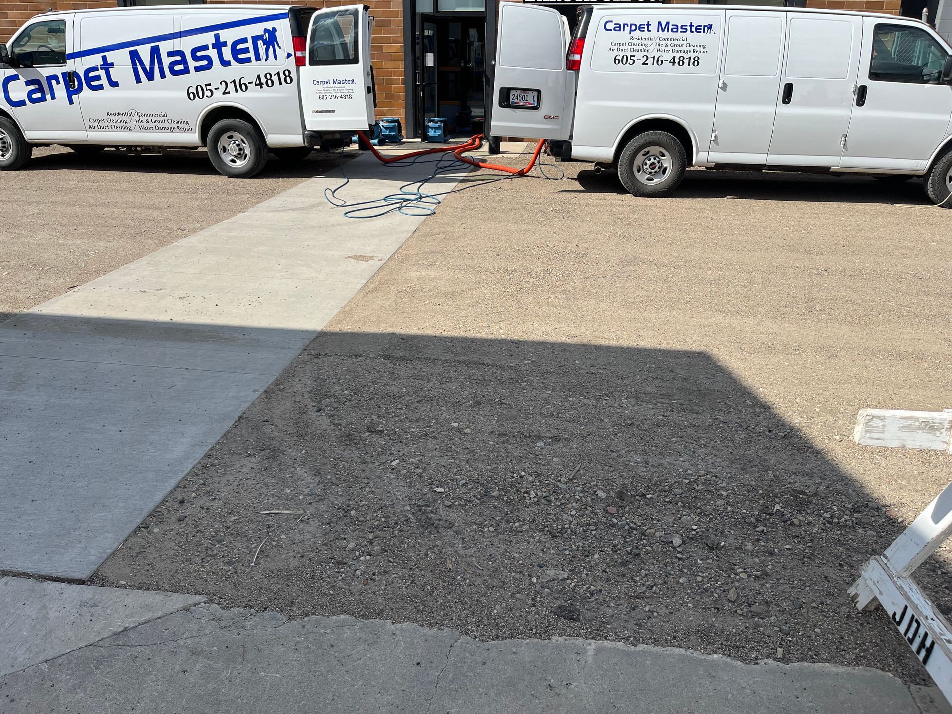 Two Carpet Master vans are parked in a parking lot.