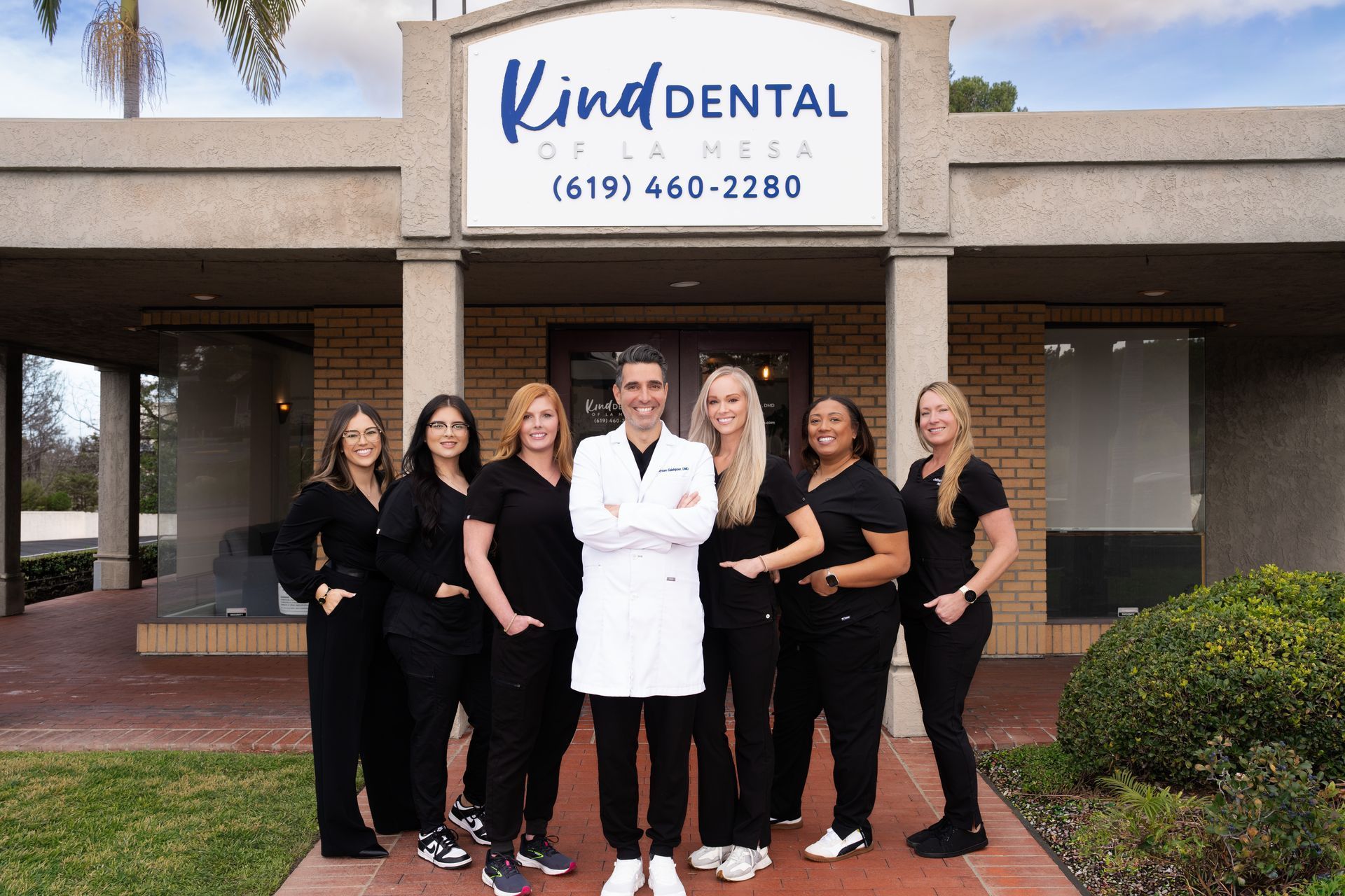 Team of dental professionals posing in front of Kind Dental office in Tennessee.