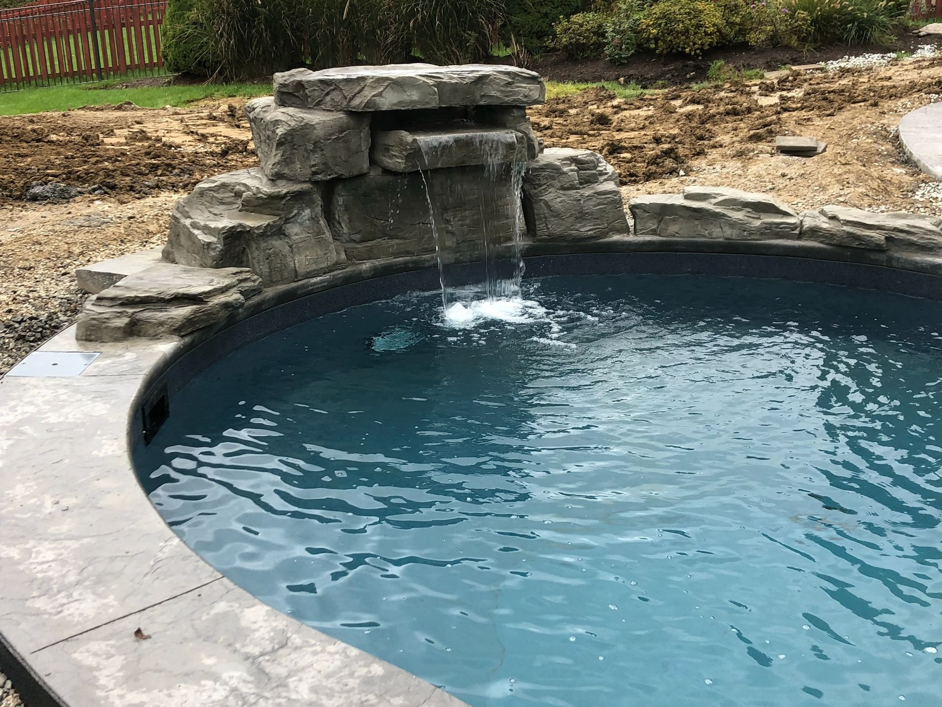 Water feature with a small waterfall into a round pool.