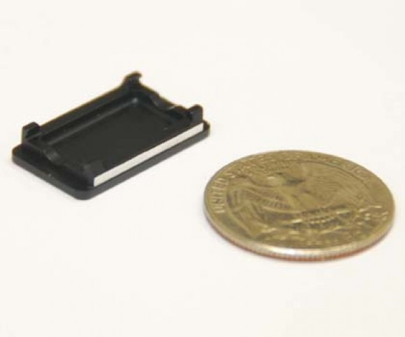 Small black plastic tray beside a gold coin for size comparison