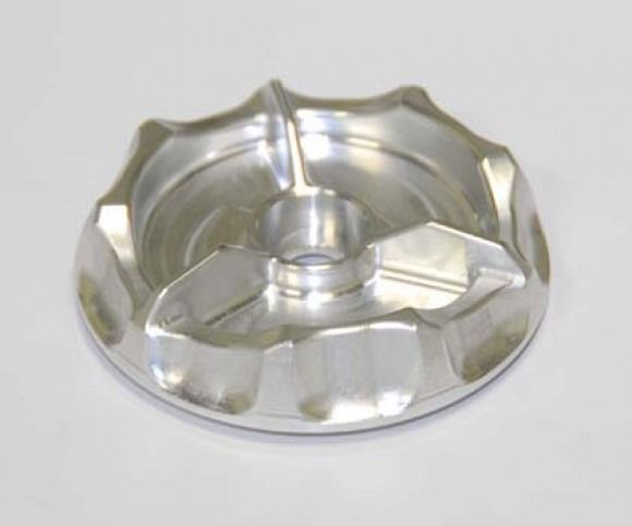 Silver metal ashtray with a central cigarette rest on a light background