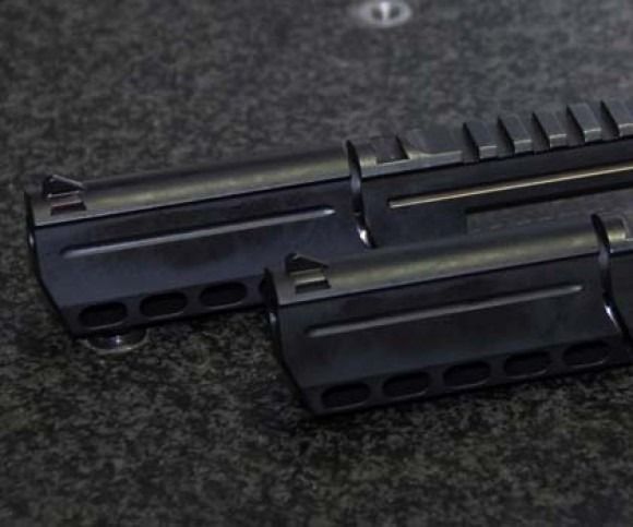 Two black rifle handguards on a dark surface, shown side by side.