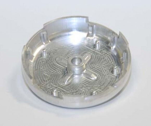 Shiny silver metal circular tray with raised tabs and a central post on a white background