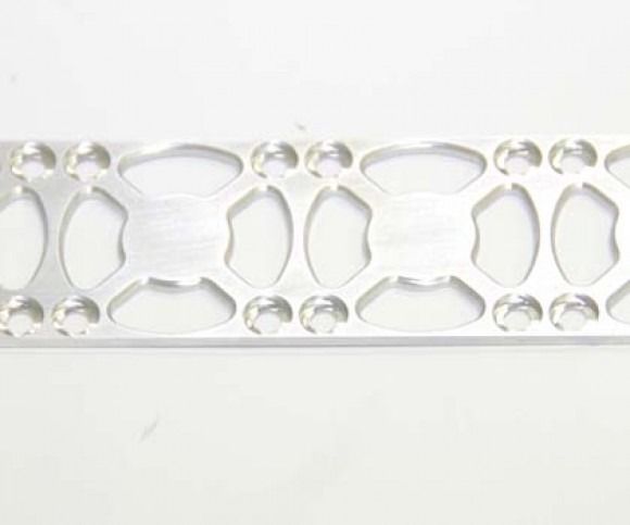 White perforated plastic lattice strip with repeating oval cutouts on a light background