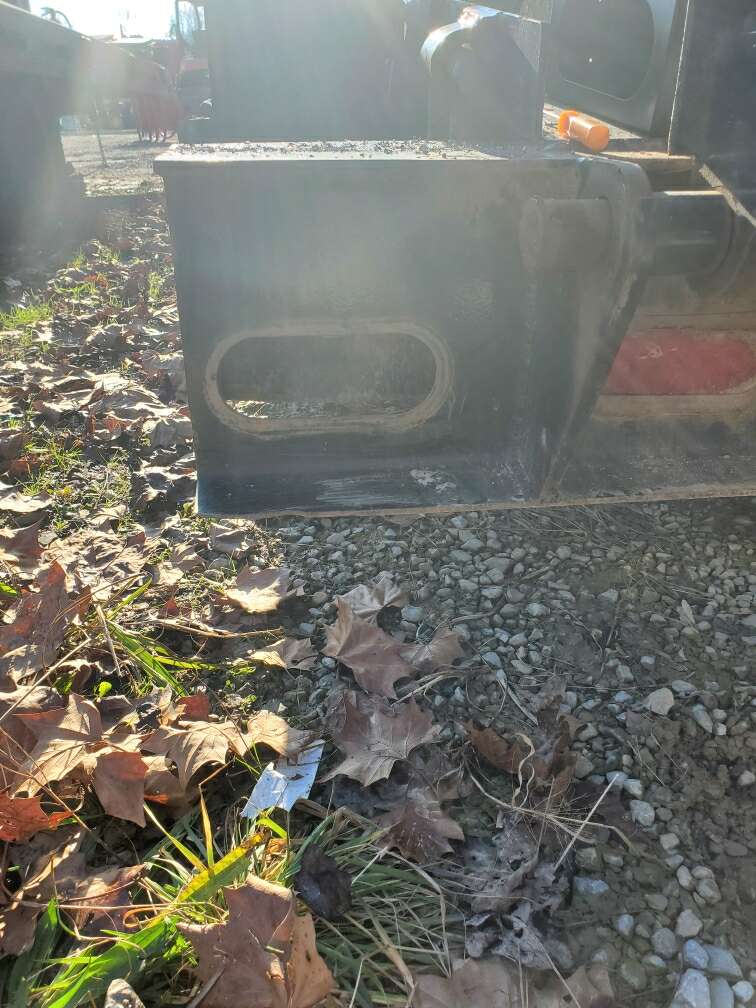 A black box is sitting on top of a pile of leaves on the ground.