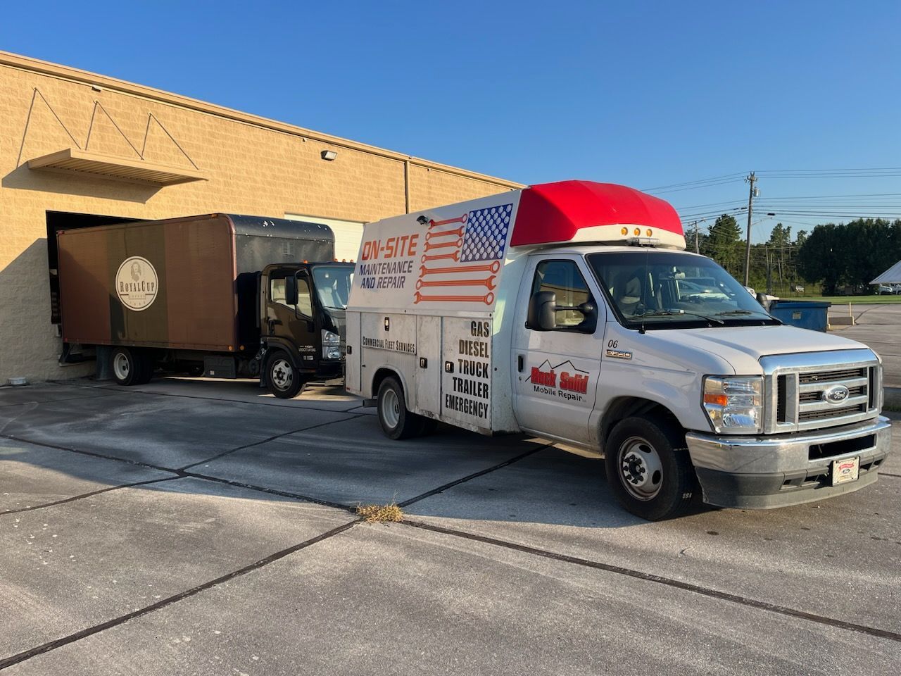 A white truck with an American flag on the side is parked in front of a building.