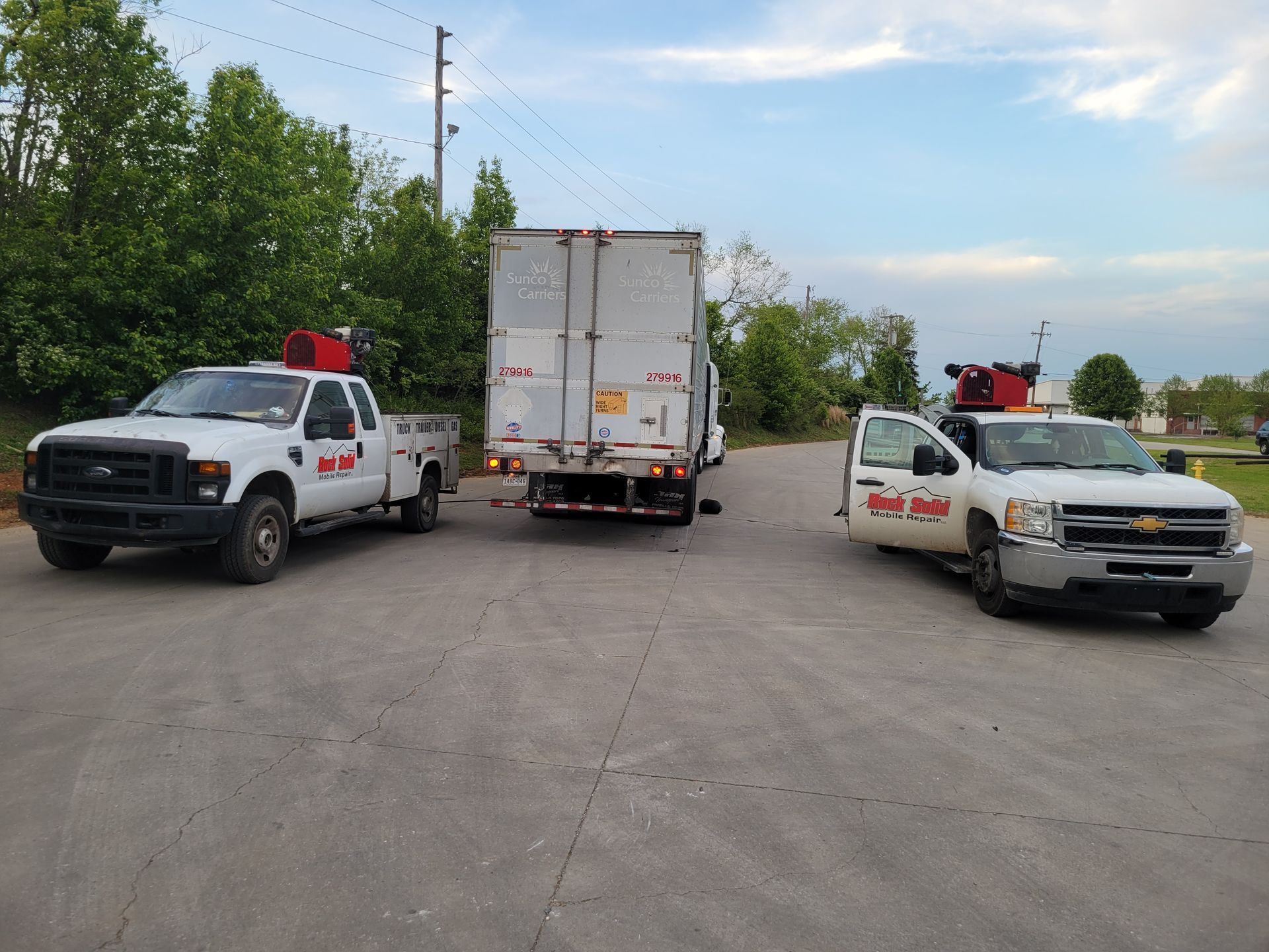 three white trucks on the road