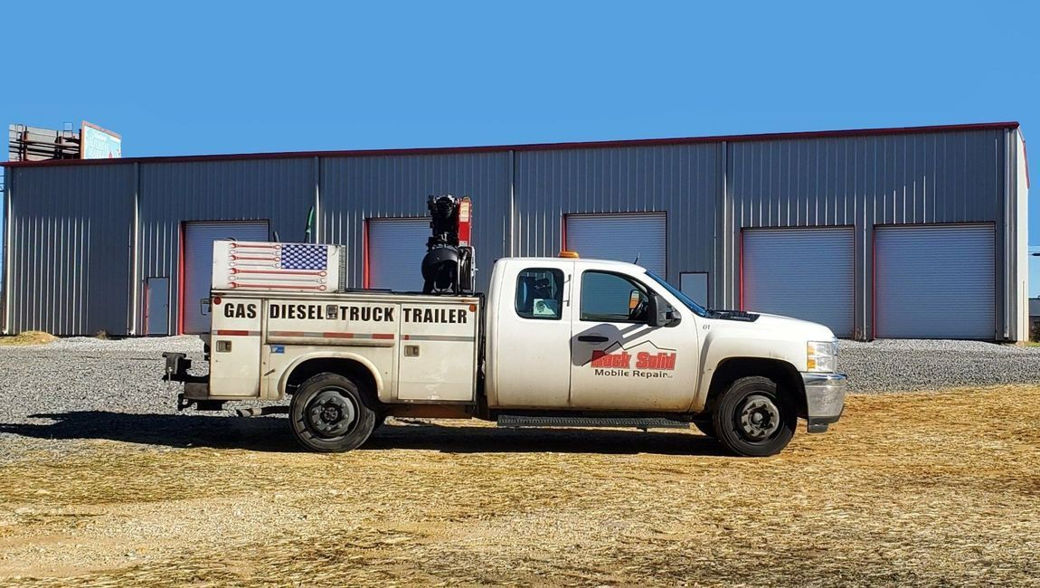 A gas diesel truck trailer is parked in front of a building