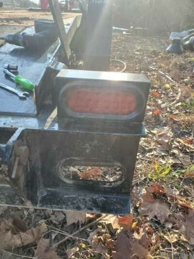 A piece of metal is sitting on top of a pile of leaves.