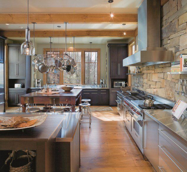 A rustic kitchen with dark wood cabinets, stainless steel appliances, a stone backsplash, and a large central island.