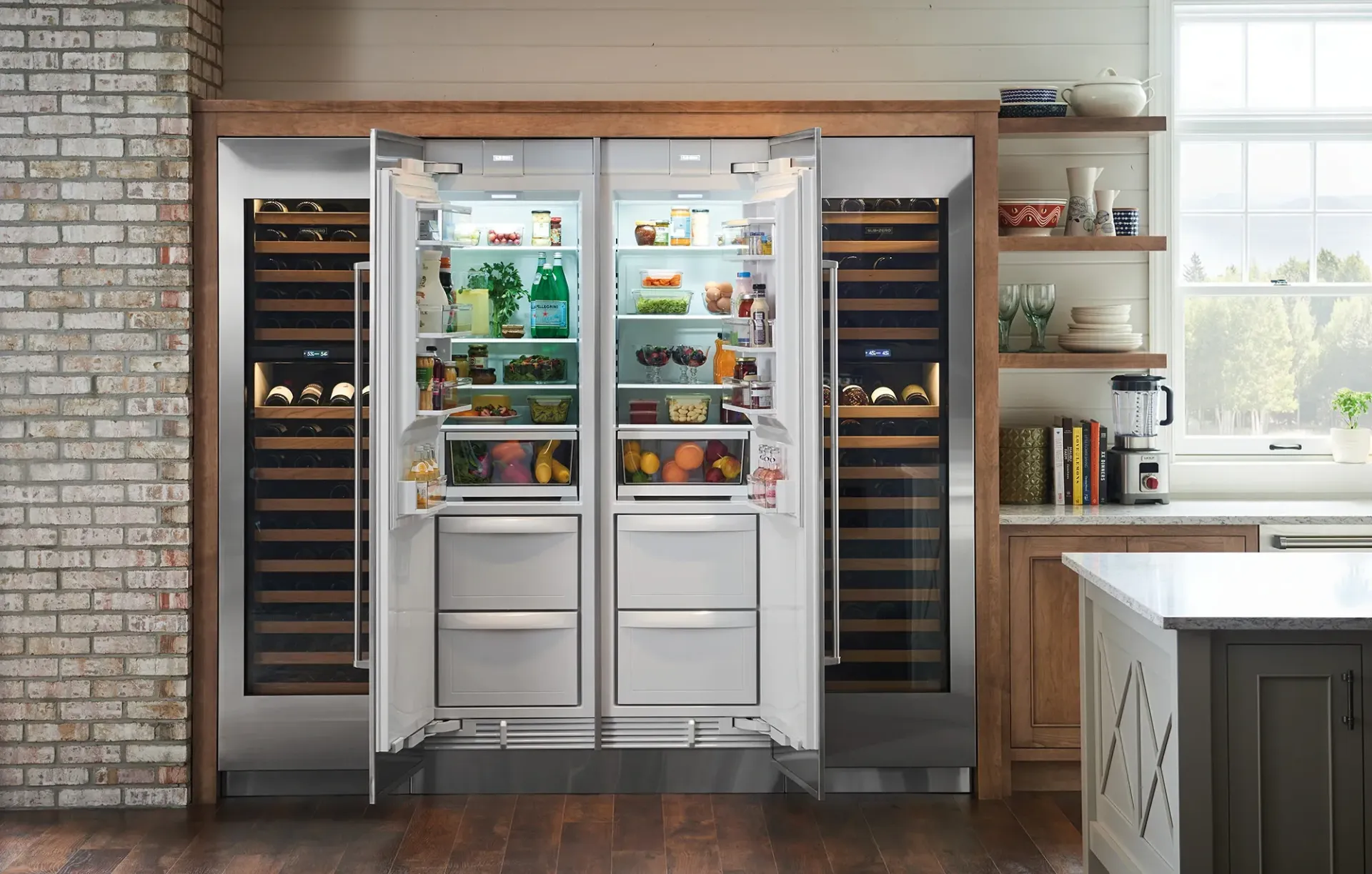 Built-in luxury kitchen appliance wall featuring a central refrigerator flanked by two wine coolers in a rustic home.