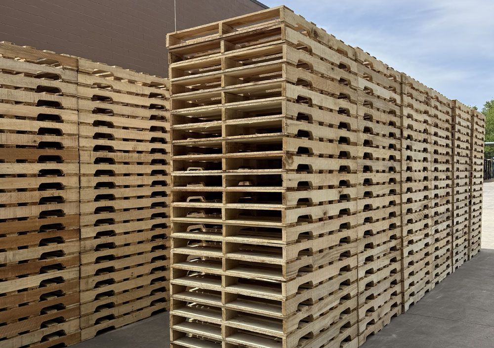 Stacks of empty wooden pallets in an outdoor industrial yard