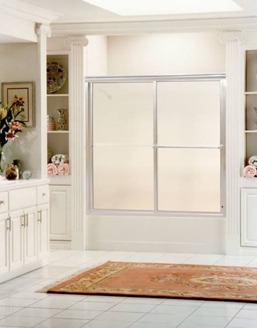 Bathroom with a shower, white cabinets, and a decorative rug.