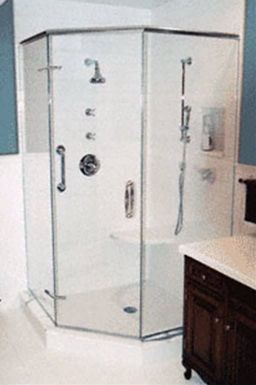 Glass-enclosed shower with chrome fixtures in a bathroom, featuring a bench seat and grab bar.