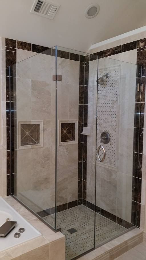 Glass shower enclosure in a tiled bathroom.