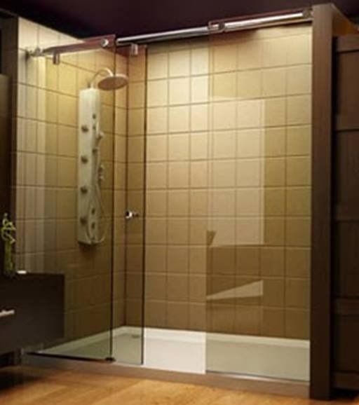 Glass shower enclosure with sliding door and beige tiled walls.