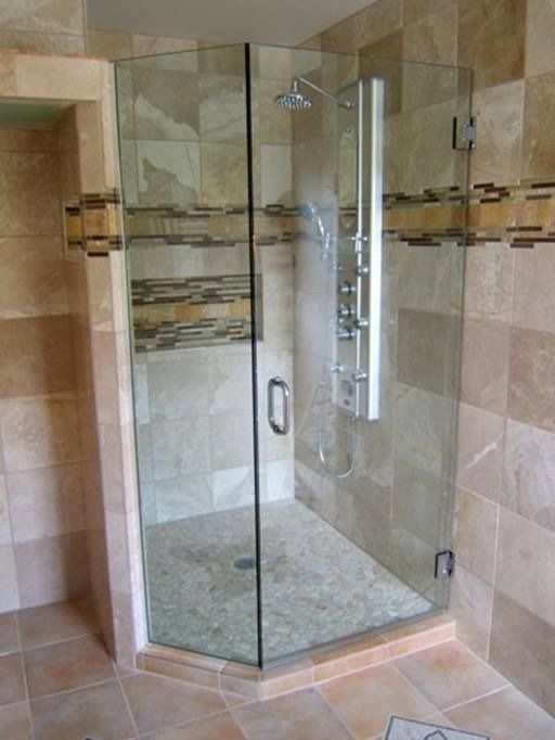 Glass shower enclosure in a bathroom with beige tile and stone accents.