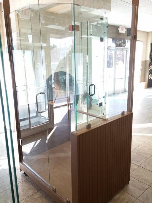 Glass enclosure with wooden accents and doors in a building.