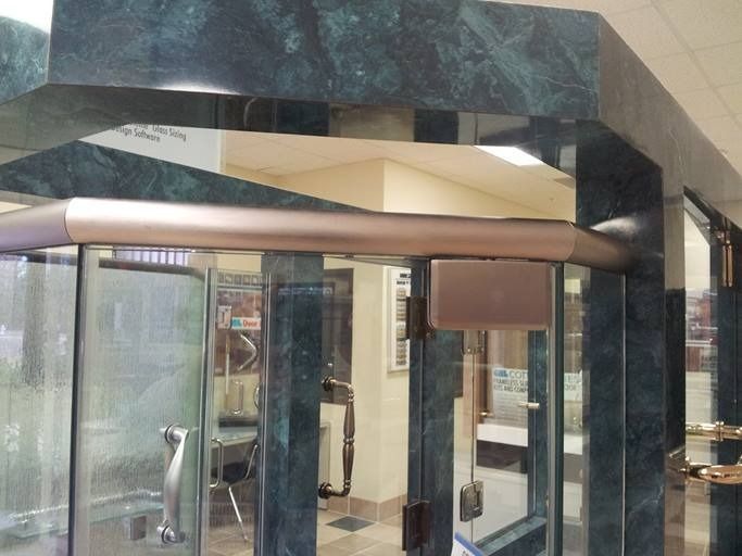 Glass doors with metal handles and a green marble frame.