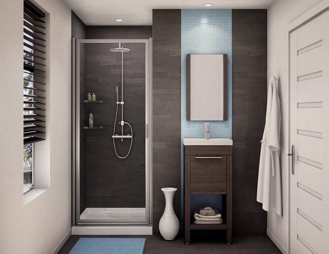 Bathroom with shower, vanity, and closed door; dark gray and blue tile walls; white vase; blue rug.