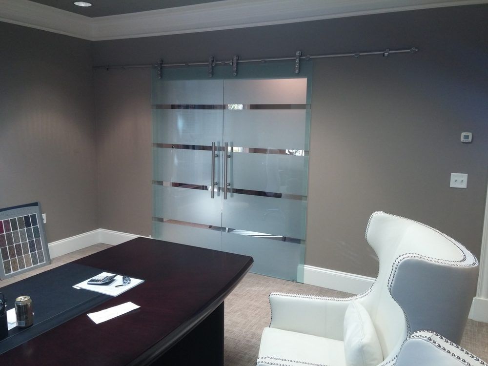 Frosted glass sliding doors in an office with a desk and white chair.