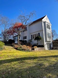 A large white house with a large lawn in front of it