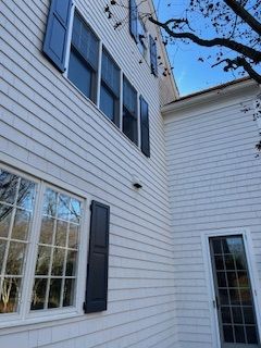 A white house with black shutters on the windows and a door