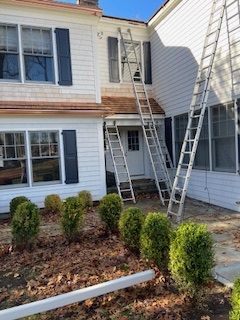 A white house with a ladder on the side of it
