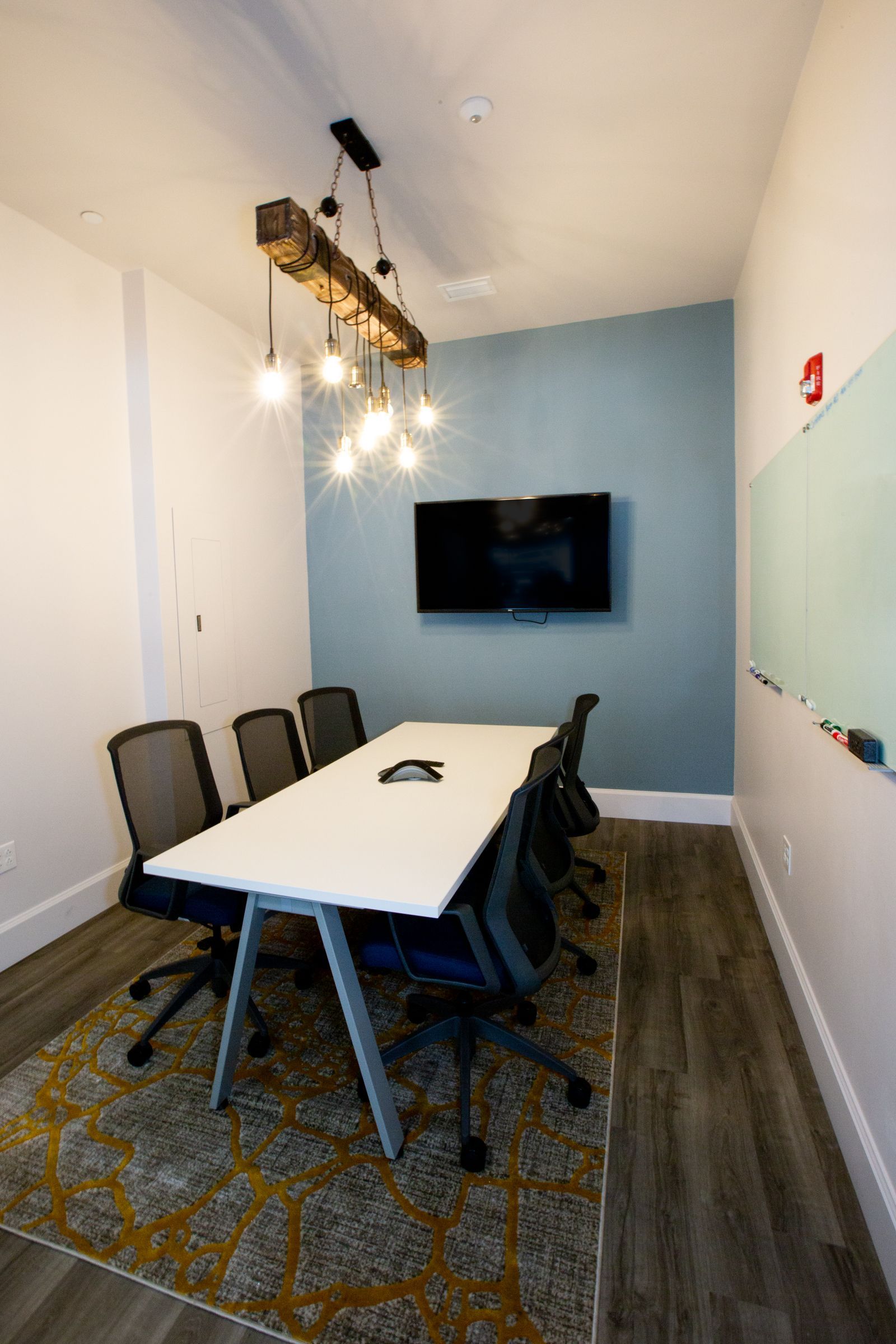 A conference room with a long table and chairs and a flat screen tv