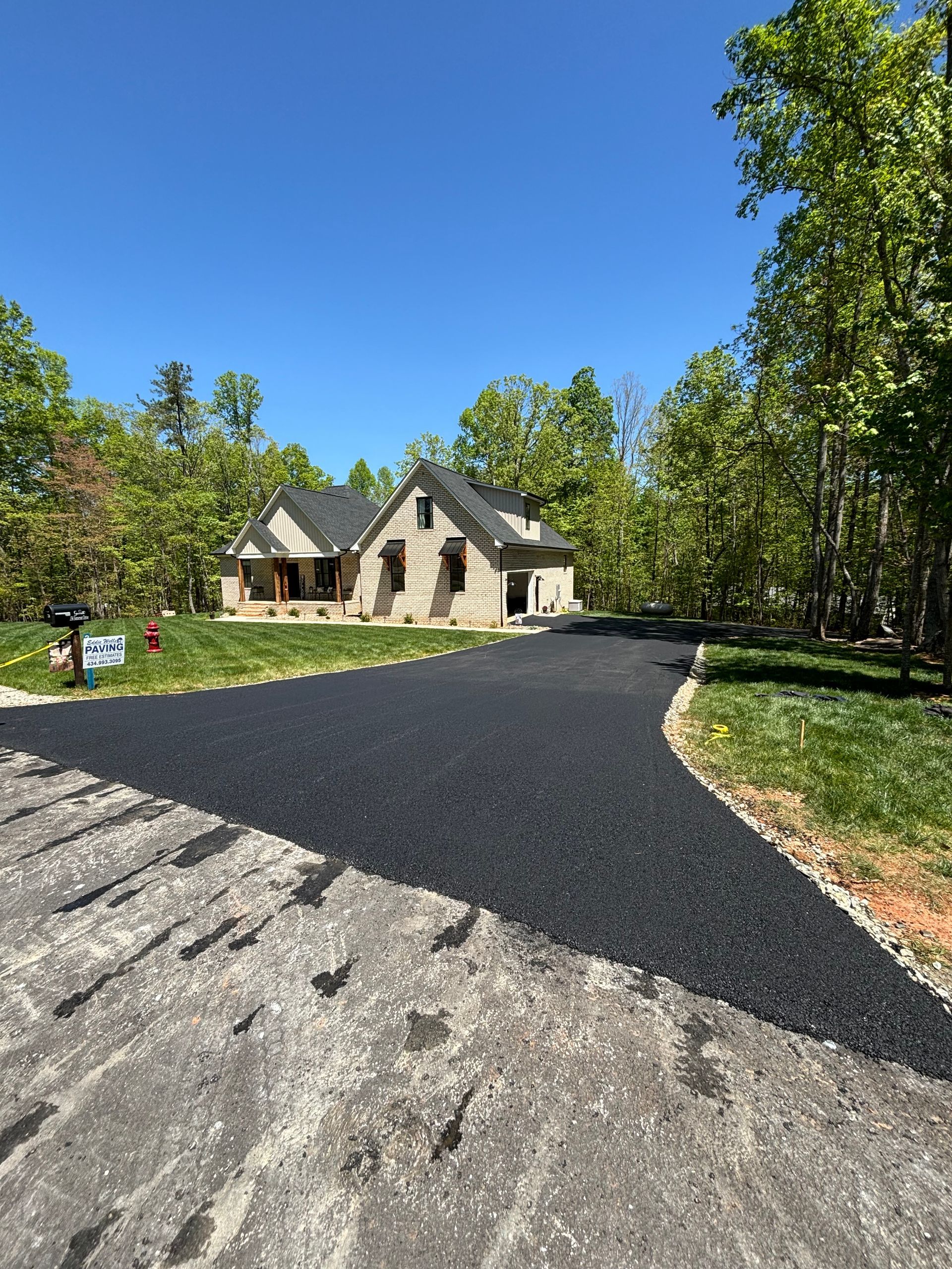 A shot of a long driveway leading up to a house