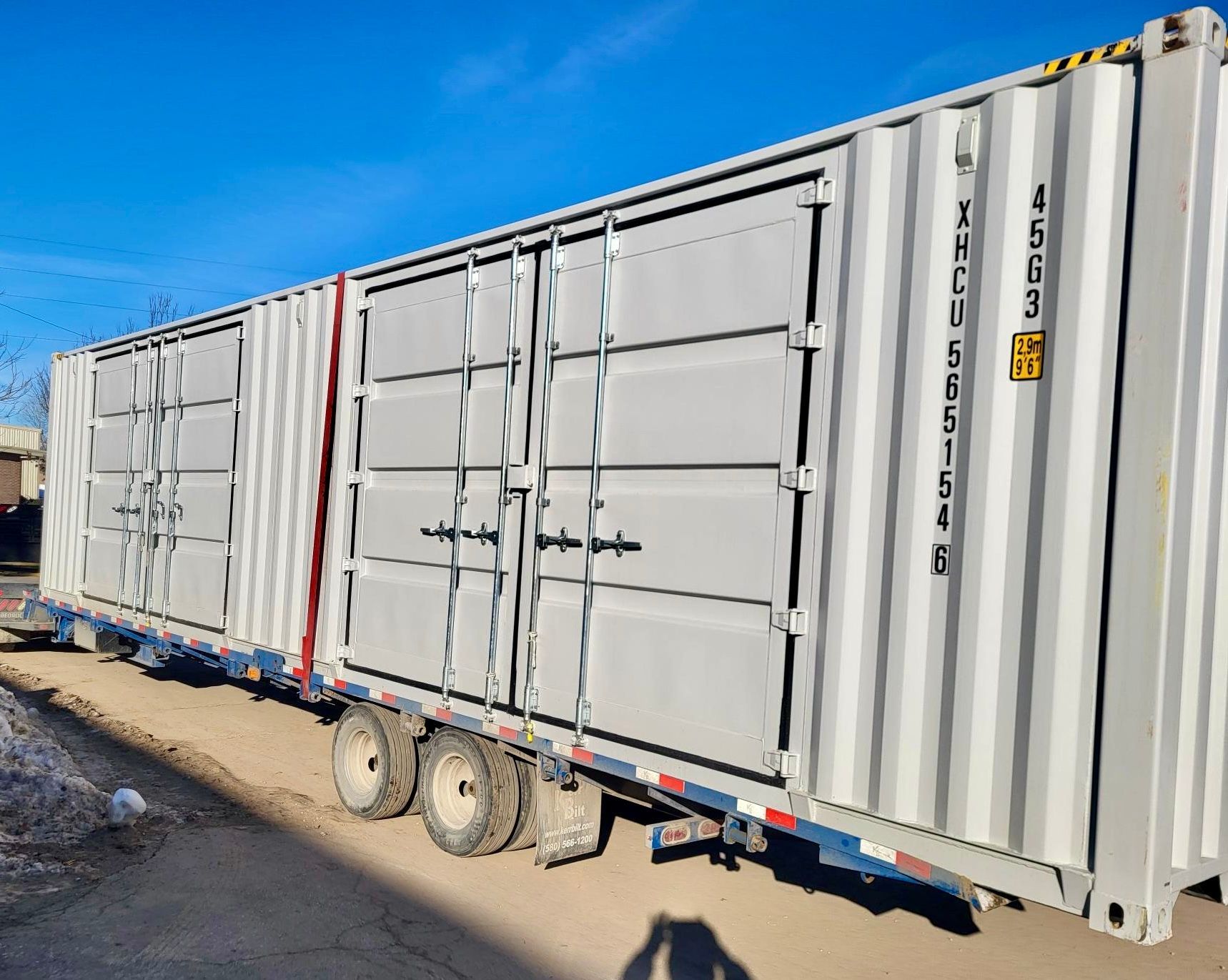 A row of shipping containers are sitting on top of a trailer