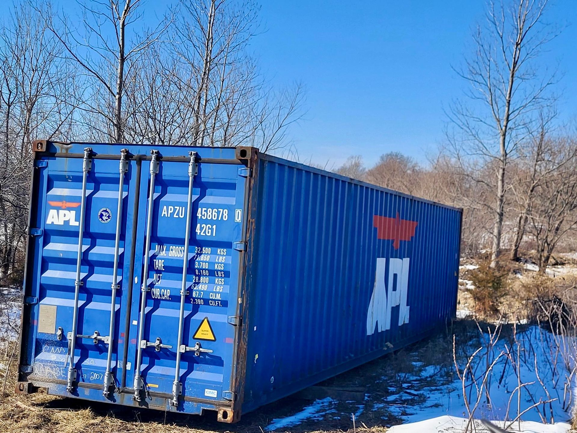 A blue shipping container with the word APL on it